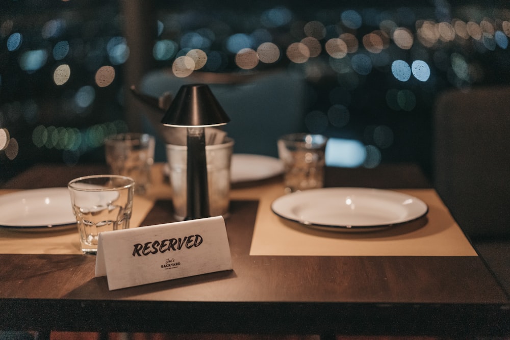 Reserved card on a set table at night, city lights behind